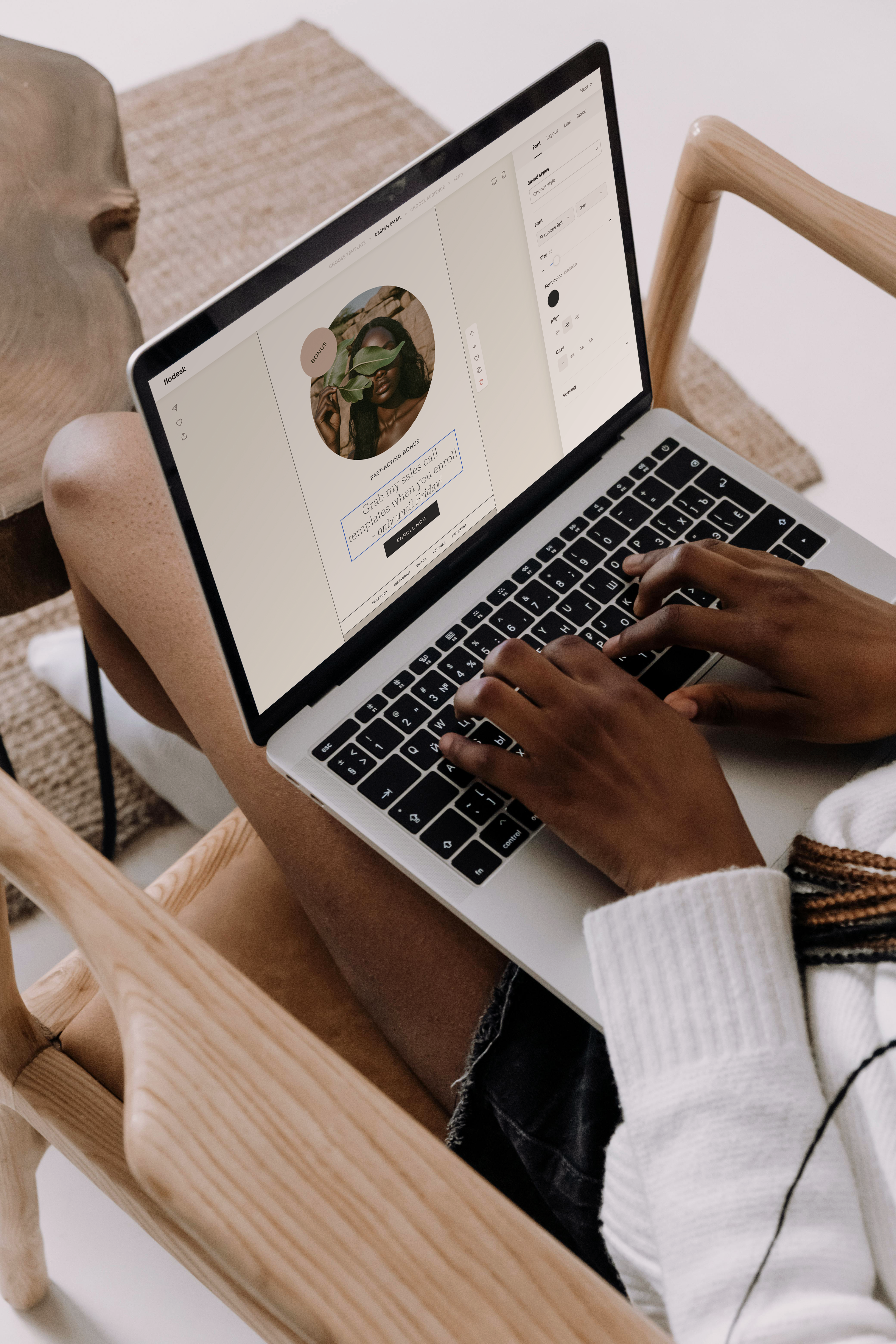Woman editing an email design in Flodesk on a laptop that's open on her lap.